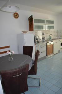 a kitchen with a table with chairs and a refrigerator at Kampor 211 in Kampor