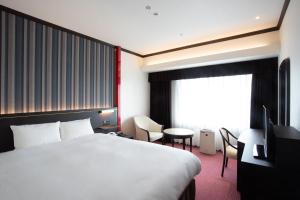 a hotel room with a bed and a window at Kobe Seishin Oriental Hotel in Kobe