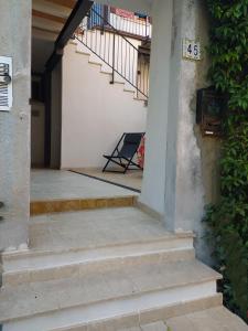 a porch with stairs and a sign on a building at Cà del borgo Historic Village in Toscolano Maderno