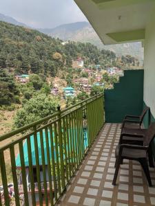 balcón con sillas y vistas a la ciudad en Golden View B&B, en Dharamshala