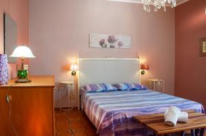 ein Schlafzimmer mit einem Bett und einem Tisch darin in der Unterkunft Casa Libertà in Castellammare del Golfo
