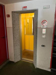 um elevador com uma porta amarela num edifício em APPARTAMENTO FOPPOLO em Foppolo