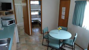 a room with a table and chairs and a kitchen at Prom Central Caravan Park in Foster