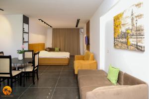 Habitación con sofá, cama y mesa. en Palm Suites Apartment-Suite en Vlorë