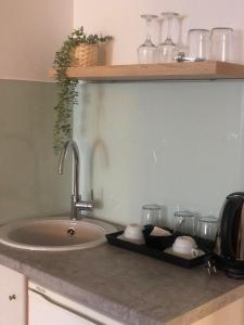 a kitchen counter with a sink and glasses on it at Villa Pantheon in Litochoro