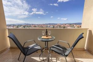 a table and chairs on a balcony with a view at Sunset Apartment in Zadar