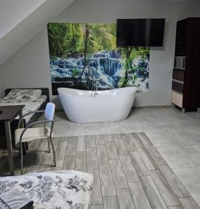 a bathroom with a tub in the middle of a room at Noclegi 24/h Leszczynek in Kutno
