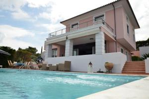 塞奥洛戈斯VILA AMALIA的一栋房子前面有游泳池的别墅