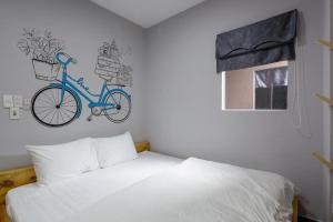 a bedroom with a bed and a bike on the wall at TUTI HOSTEL in Da Nang