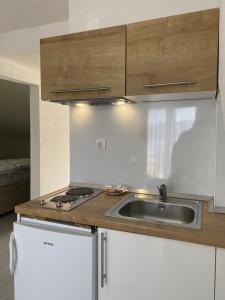 een keuken met een wastafel en een fornuis bij Apartments Villa Glavinić in Neum