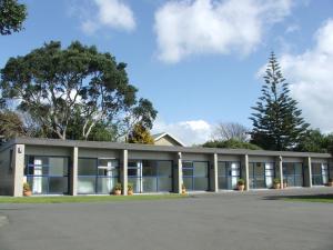 an office building with large windows and a tree at New Plymouth TOP 10 Holiday Park in New Plymouth