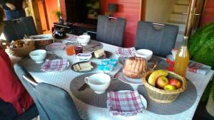 a table with a table cloth with baskets of fruit on it at Bien être et détente chez côté campagne et jardin in Ohnenheim