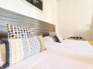 1 dormitorio con 2 camas y almohadas coloridas en Viva Riviera - 3 Rue Commandant André, en Cannes