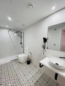 a bathroom with a toilet and a sink and a mirror at Jacaranda Apartments & Studios in Es Cana