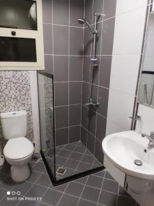 a bathroom with a shower and a toilet and a sink at Altelal Tower Apartment in Makkah +2 photos
