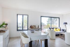a kitchen and living room with a white table and chairs at Villa Bel Air in Criel-sur-Mer