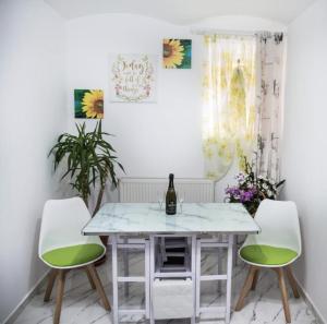 a dining room with a white table and two green chairs at Wall St House in Sibiu