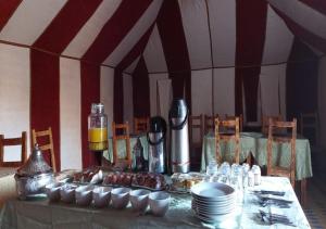 une table avec des assiettes et des tasses en haut dans l'établissement Desert Life Camp, à Merzouga 26 autres photos