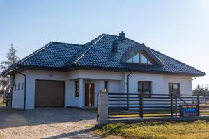 ein Haus mit einem Metalldach darüber in der Unterkunft Apartamenty Jantar in Łeba