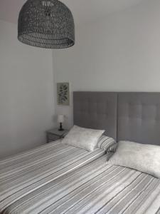 a bedroom with a large bed and a chandelier at La Fuentona in Celorio