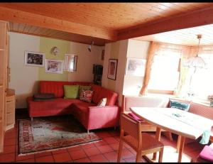 a living room with a red couch and a table at Haus Edda Einfamilienhaus in Gundersheim