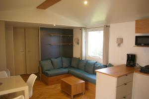 un soggiorno con divano blu e finestra di Mobile Home OuiReves 304 facing the Mediterranean a Lattes