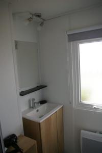 een badkamer met een wastafel en een raam bij Mobile Home OuiReves 304 facing the Mediterranean in Lattes