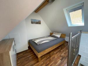 um pequeno quarto com uma cama no sótão em Ferienwohnung Häusla em Hirschaid