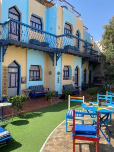 a building with a yard with colorful chairs and tables at Monica Hotel in Dahab