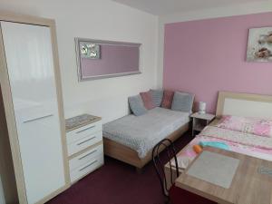 Dormitorio pequeño con cama y espejo en Azalka Penzion, en Brno