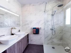 ein Bad mit 2 Waschbecken und einer Dusche in der Unterkunft Evolve Coliving Guesthouse in Sliema