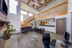 a living room with leather furniture and a staircase at Super 8 by Wyndham Kansas City Airport North in Kansas City