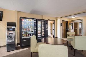 a restaurant with a refrigerator and a table and chairs at Rodeway Inn & Suites Portland - Jantzen Beach in Portland