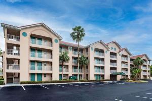 un gran edificio de apartamentos con palmeras en un aparcamiento en Vacation Villas 2, a Ramada by Wyndham en Kissimmee