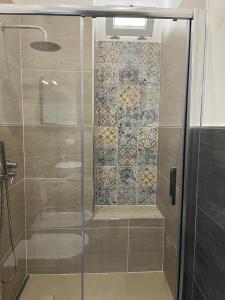 een douche met een glazen deur in een badkamer bij La casa di Alessandro in Noto +17 foto's