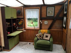 Ferienwohnung Zeitenhof في Suderburg: غرفة صغيرة بها كرسي أخضر ونافذة