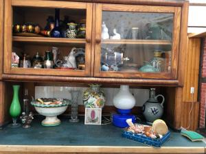 a cabinet filled with lots of vases and other items at Ferienwohnung Zeitenhof in Suderburg