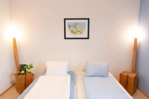 Uznach的住宿－貝恩特賽住宿加早餐旅館，一间设有两张床的客房,墙上挂着一张照片