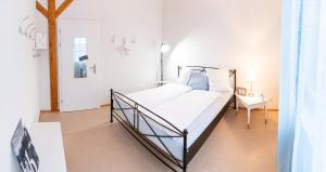 a white bedroom with a bed and a table at BnB Entensee in Uznach