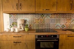 a kitchen with wooden cabinets and a tile wall at Lübbenauer Spreewaldnest in Lübbenau