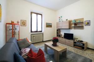 sala de estar con sofá azul y TV en Passaggio in Val d' Orcia, en Torrenieri