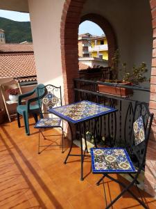 un patio con 2 mesas y sillas en un balcón en La Casa del Cuore, en Muravera