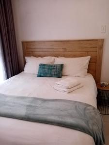 a bed with two towels sitting on top of it at LANGA 'S COZY GUESTHOUSE in Pretoria