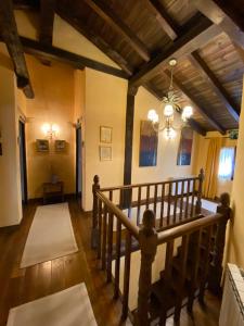 a hallway with a staircase in a house with a chandelier at Casa Rural Dos Reales in San Cristóbal de Boedo