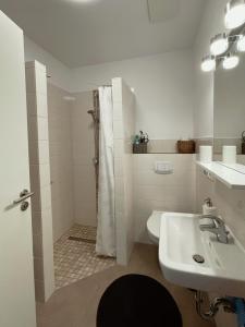 uma casa de banho branca com um chuveiro e um lavatório. em Ferienwohnung Apfelrose em Trent