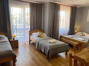 a hotel room with two beds and a window at Willa Mona in Międzywodzie
