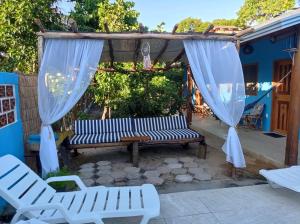 a patio with a bench and curtains on it at pousada corais de abrolhos in Caravelas