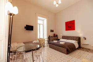 una camera da letto con un letto e un tavolo di vetro di Suites Trinità in Toledo street a Napoli Altre 53 foto