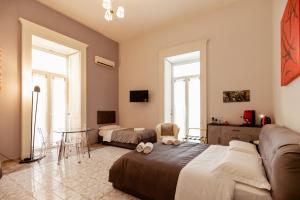 una camera da letto con un letto, un divano e un tavolo di Suites Trinità in Toledo street a Napoli