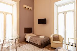 a bedroom with a bed and a table and a chair at Suites Trinità in Toledo street in Naples
